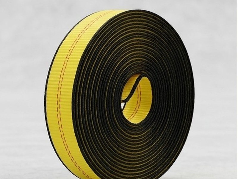 A roll of webbing standing on its edge, wound flat and even